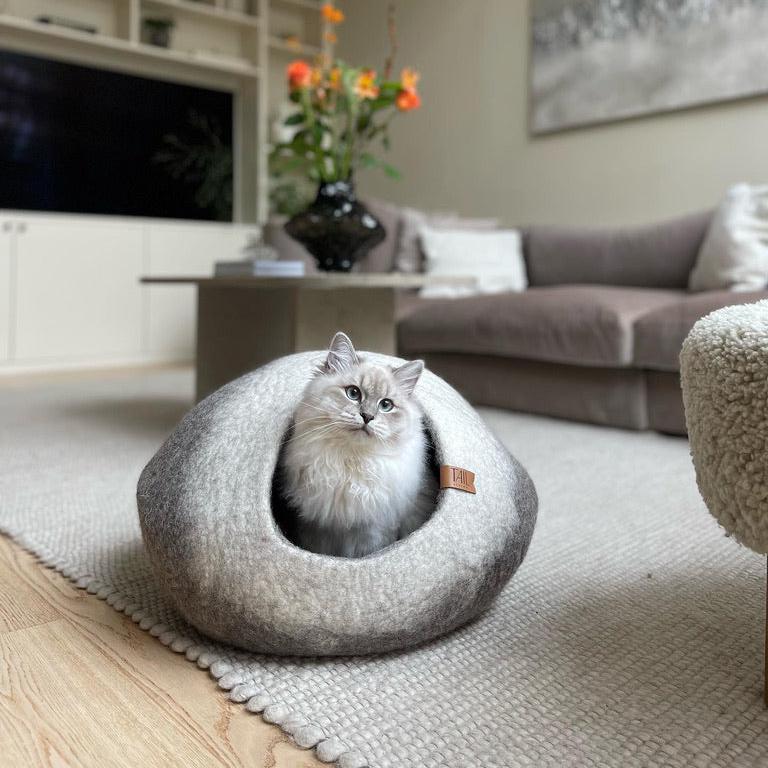 Image - Cosy cat cave from the Essential Kit by Tail Living, featuring a soft, felted design with a fluffy cat inside. Perfect for comfort and security.